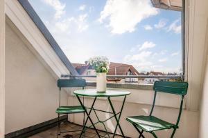 2 stoelen en een tafel op een balkon met een raam bij FeWo Segeltörn in Zingst