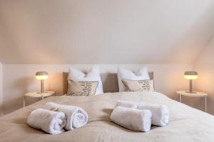 een slaapkamer met een groot bed en handdoeken bij FeWo Segeltörn in Zingst