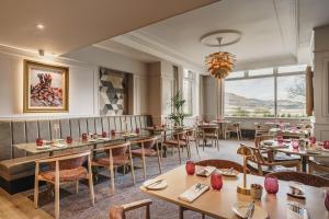 a restaurant with tables and chairs and a large window at Lodore Falls Hotel & Spa in Keswick