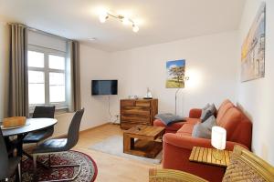 ein Wohnzimmer mit einem Sofa und einem Tisch in der Unterkunft Miramar App. 15 in Ahlbeck