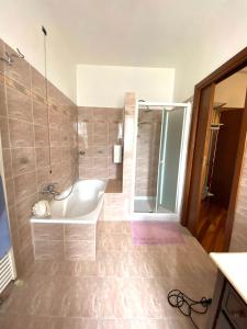 ein Bad mit einer Badewanne, einer Dusche und einem Waschbecken in der Unterkunft Giulietta Home in Belfiore