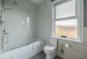 La salle de bains est pourvue de toilettes, d'une douche et d'une fenêtre. dans l'établissement Entire 2-bedroom house with garden, à York