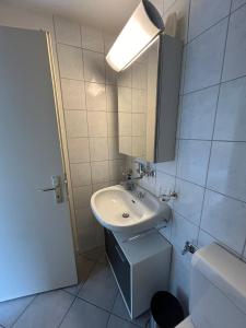 La salle de bains blanche est pourvue d'un lavabo et d'un miroir. dans l'établissement Tgesa Tgampi T20, à Savognin