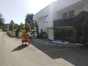 a building with a flower pot sitting on a red bench at Garni Weingut in Merano