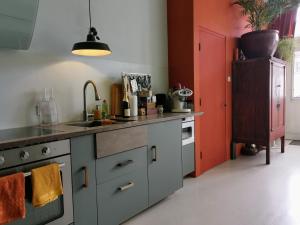 een keuken met een wastafel en een fornuis bij Slapen aan de Sluis in Utrecht