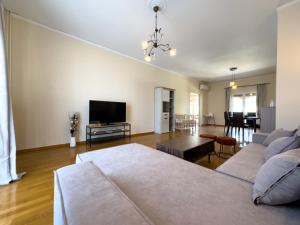 Il comprend un salon doté d'un canapé et d'une télévision à écran plat. dans l'établissement Gtrip Piraeus Coast Apartment - 7058, au Pirée