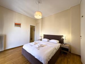 - une chambre avec un grand lit et des draps blancs dans l'établissement Gtrip Piraeus Coast Apartment - 7058, au Pirée
