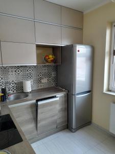 a kitchen with a stainless steel refrigerator and a sink at Apartament Leśna 18 in Olsztyn