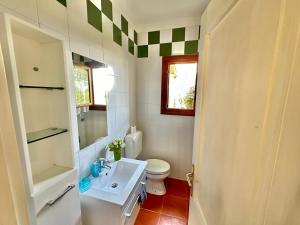 a bathroom with a white toilet and a sink at Casa Alba in Stintino