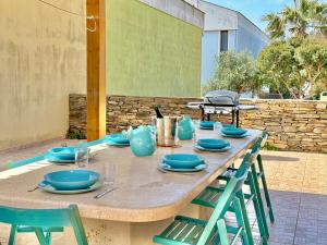 a table with blue plates and chairs on a patio at Casa Alba in Stintino