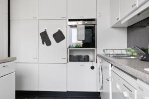eine weiße Küche mit weißen Schränken und einem Herd in der Unterkunft CityCharme-Apartment in Braunschweig