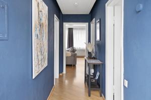 einen Flur mit blauen Wänden und einem Tisch in einem Zimmer in der Unterkunft CityCharme-Apartment in Braunschweig
