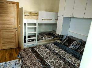 a bedroom with two bunk beds and a door at Sunset Retreat Apartment Bar in Bar