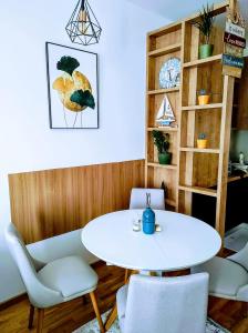 a dining room with a white table and chairs at Sunset Retreat Apartment Bar in Bar