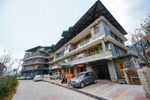 a building with a car parked in front of it at Misty Hills in Manāli