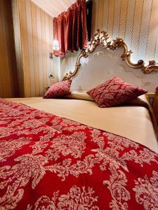 un letto rosso e bianco con copriletto rosso e bianco di Hotel al Graspo de Ua a Venezia