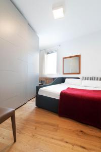 een slaapkamer met een groot bed en een rode deken bij Attico Treviso Centro in Treviso