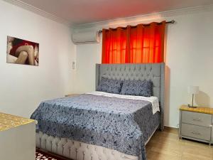um quarto com uma cama e uma janela vermelha em Casa Deisy em Santiago de los Caballeros
