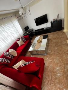 a living room with a red couch and a tv at Casa Deisy in Santiago de los Caballeros