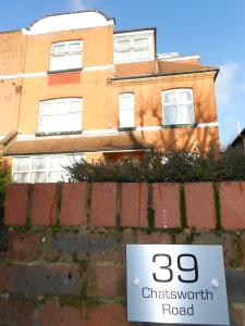 ein Schild an einer Backsteinmauer vor einem Haus in der Unterkunft 24/7 London Hostel in London
