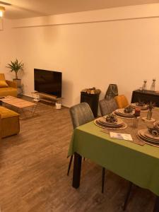 a living room with a table and a flat screen tv at Nice Cozy Appartment Remich in Remich