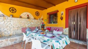 ein Esszimmer mit einem Tisch und weißen Stühlen in der Unterkunft Casa Gonzalez Villanueva de la Concepcion by Ruralidays in Villanueva de la Concepción