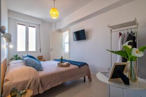 a bedroom with a bed with a table and a window at San Michele Suites&Rooms in Alghero