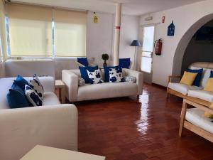 een woonkamer met witte banken en blauwe kussens bij Dona Ana - Residencial in Lagos