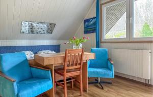 a dining room with a table and two blue chairs at Nice Home In Lidzbark Warminski With House A Panoramic View in Lidzbark Warmiński