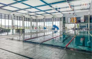 a swimming pool with two lanes of water in a building at Nice Home In Lidzbark Warminski With House A Panoramic View in Lidzbark Warmiński