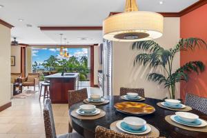 a dining room with a black table with chairs and a dining room at Ko Olina Beach Villas O402 in Kapolei