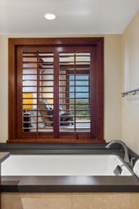une salle de bains avec fenêtre, baignoire et vue dans l'établissement Ko Olina Beach Villas O1001, à Kapolei