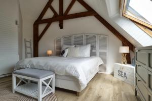 ein Schlafzimmer mit einem weißen Bett und einem Fenster in der Unterkunft Beautiful villa with heated indoor pool, large garden close to beach, 8 people in Moëlan-sur-Mer