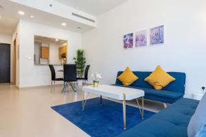 - un salon avec un canapé bleu et une table dans l'établissement Lux BnB Bellevue Tower Burj Khalifa Views, à Dubaï