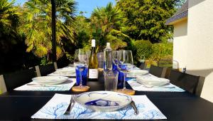 einen langen Tisch mit Tellern und Weingläsern darauf in der Unterkunft Beautiful villa with heated indoor pool, large garden close to beach, 8 people in Moëlan-sur-Mer