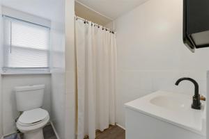 a white bathroom with a toilet and a sink at 217 E Hildreth Ave, Unit 4 in Wildwood
