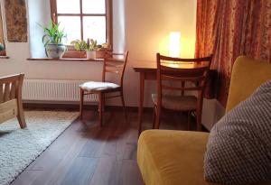 sala de estar con mesa, sillas y ventana en Charmantes Zimmer mit Bad im Stadtzentrum, en Pottenstein