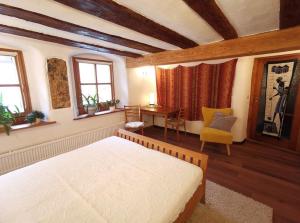 1 dormitorio con 1 cama, escritorio y ventanas en Charmantes Zimmer mit Bad im Stadtzentrum, en Pottenstein