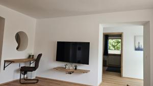 sala de estar con TV de pantalla plana en la pared en wohnung-nummer-4, en Pielenhofen