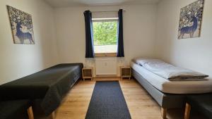 une chambre avec deux lits et une fenêtre dans l'établissement wohnung-nummer-4, à Pielenhofen