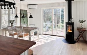 瑟爾沃斯堡的住宿－3 Bedroom Beautiful Home In Slvesborg，厨房以及带燃木炉的用餐室。