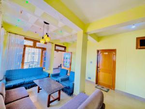 a living room with blue couches and a table at Grand view lodge and Restaurant Dharamshala - Partial Prepayment required to confirm booking in Dharamshala