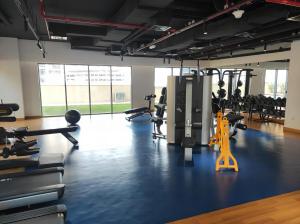 une salle de sport avec des tapis de course et une personne jaune au milieu dans l'établissement Lux BnB Bellevue Tower Burj Khalifa Views, à Dubaï