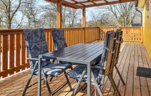 a wooden table and two chairs on a deck at Amazing Home In Ronneby With Kitchen in Ronneby