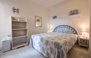 1 dormitorio con 1 cama con manta azul y blanca en Lovely Home In Arbus With Kitchen, en Arbus