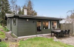 a green tiny house with a table and chairs at 2 Bedroom Awesome Home In Vordingborg in Vordingborg
