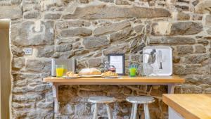 a stone wall with a table with food on it at Beech Cottage in Youlgreave