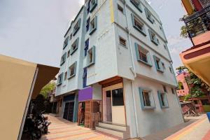 ein hohes Gebäude mit blauen Fenstern auf einer Straße in der Unterkunft SPOT ON Shree Gajanan in Aurangabad