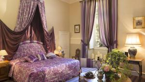 a bedroom with a purple bed with purple curtains at Château de Noizay - ChâteauZen in Noizay