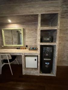 a small room with a desk with a sink and a refrigerator at The Niti Hut's Lembongan in Nusa Lembongan